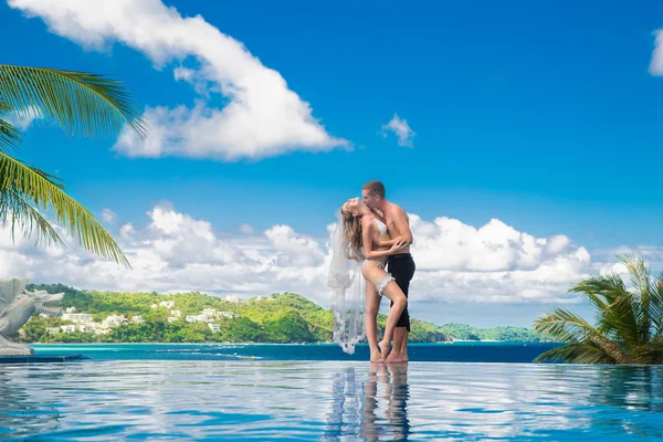 Vackra unga brud i en vit bikini, slöja och strumpeband på henne — Stockfoto