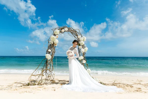 Beautiful brunette fiancee in white wedding dress with big long — Stock Photo, Image