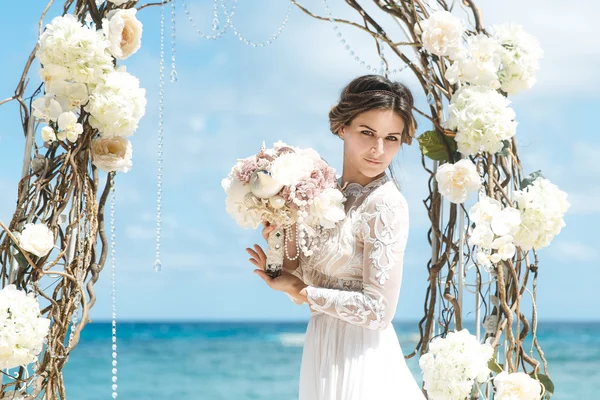 Beautiful brunette fiancee in white wedding dress with big long — Stock Photo, Image