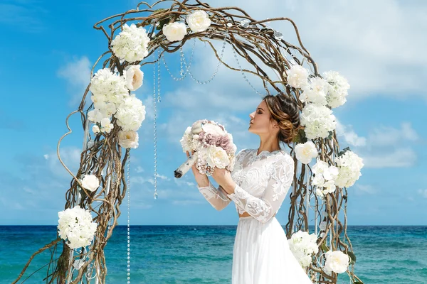 Beautiful brunette fiancee in white wedding dress with big long — Stock Photo, Image