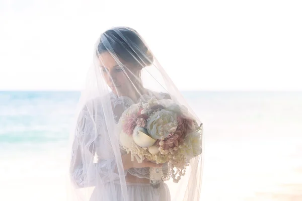 Beautiful brunette fiancee in white wedding dress with big long — Stock Photo, Image