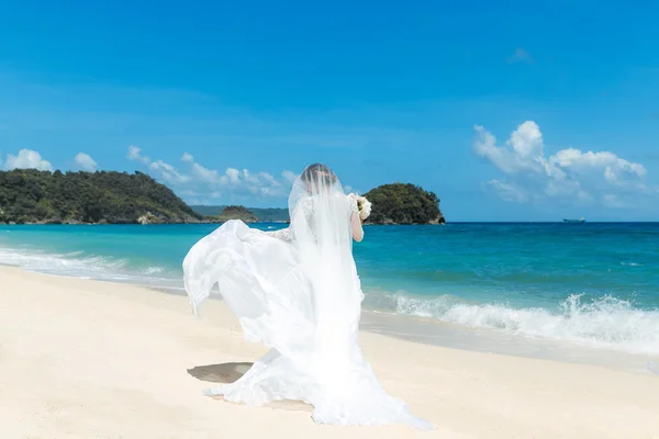 Beautiful brunette fiancee in white wedding dress with big long — Stock Photo, Image