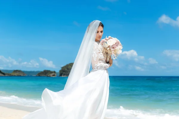 Beautiful brunette fiancee in white wedding dress with big long — Stock Photo, Image