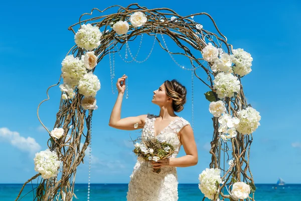 Beautiful brunette fiancee in white wedding dress with big long — Stock Photo, Image