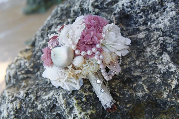 Svatební Svatební kytice na skalách. Modré moře v pozadí. Svatba a líbánky v tropech. — Stock fotografie