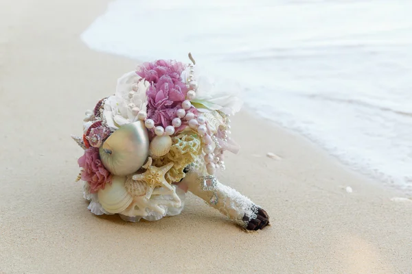 Wedding bridal bouquet on the rocks. Blue sea in the background. Wedding and honeymoon in the tropics. — Stock Photo, Image