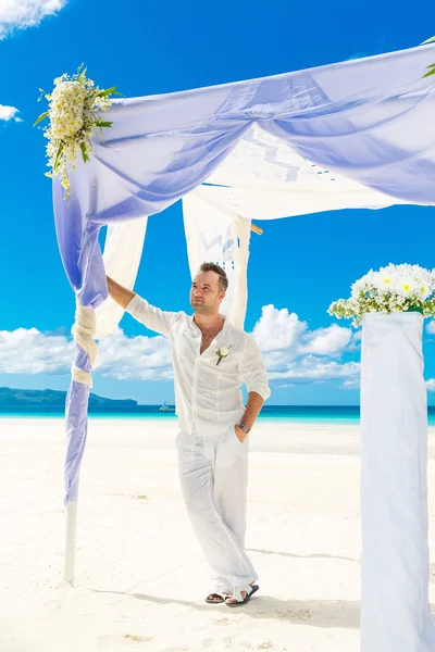 De ceremonie van het huwelijk op een tropisch strand in blauw. Wacht totdat de bruidegom — Stockfoto
