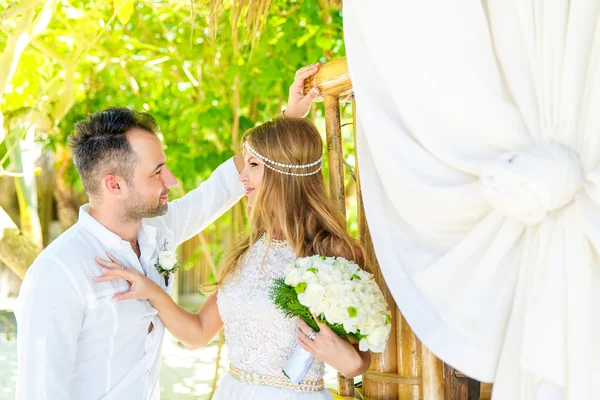 Happy bride and groom having fun on a tropical garden under the — Stock Photo, Image
