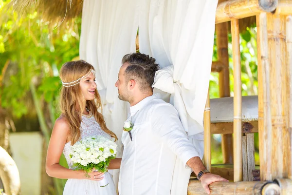 Novia feliz y novio divirtiéndose en un jardín tropical bajo el — Foto de Stock