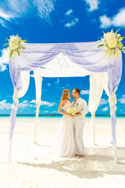 Ceremonia de boda en una playa tropical en blanco. novio feliz y b — Foto de Stock