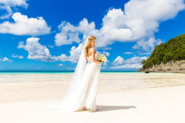 Beautiful blond bride in white wedding dress with big long white — Stock Photo, Image