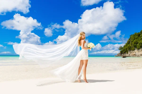 Beautiful blond bride in white wedding dress with big long white — Stock Photo, Image