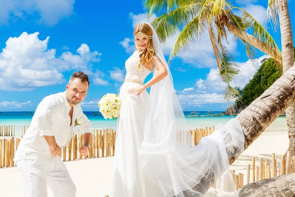 Beautiful blond bride in white wedding dress with big long white — Stock Photo, Image