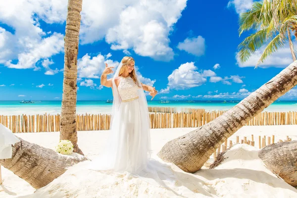 Schöne blonde Braut im weißen Hochzeitskleid mit großen langen weißen — Stockfoto