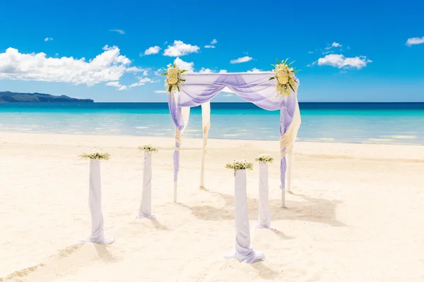 Bruiloft op het strand. Huwelijksboog versierd met bloemen op tr — Stockfoto