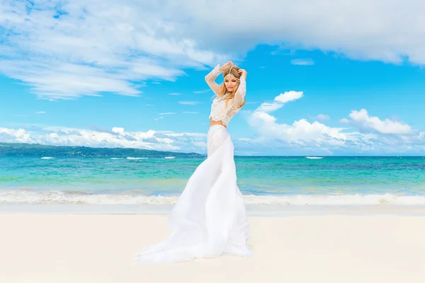 Beautiful blond bride in white wedding dress with big long train — Stock Photo, Image