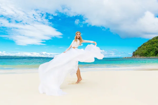 Beautiful blond bride in white wedding dress with big long train — Stock Photo, Image