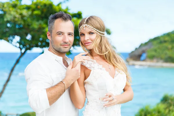 Lyckliga bruden och brudgummen att ha kul på en tropisk strand. Bröllop en — Stockfoto