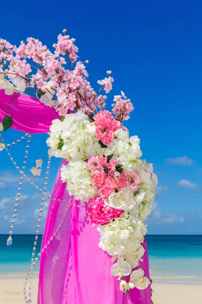 Svatba na pláži. Svatební oblouk v purpurové výzdobě s Flo — Stock fotografie