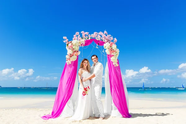 Cérémonie de mariage sur une plage tropicale en violet. Joyeux marié et — Photo