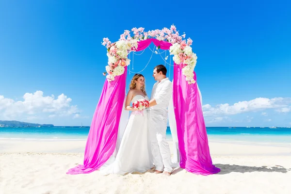 Cerimônia de casamento em uma praia tropical em roxo. Feliz noivo e — Fotografia de Stock