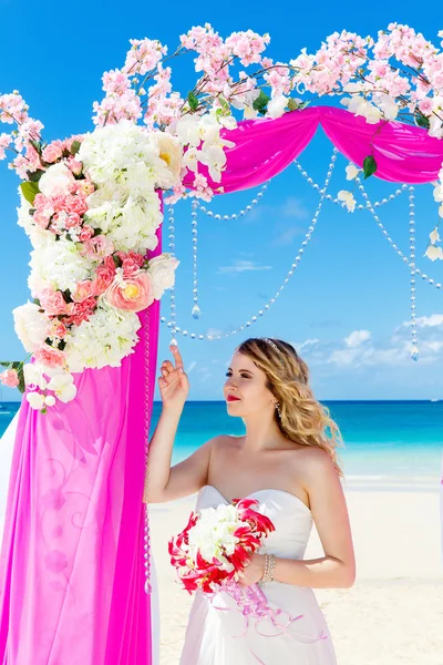 Cerimônia de casamento em uma praia tropical em roxo. Noiva loira feliz — Fotografia de Stock