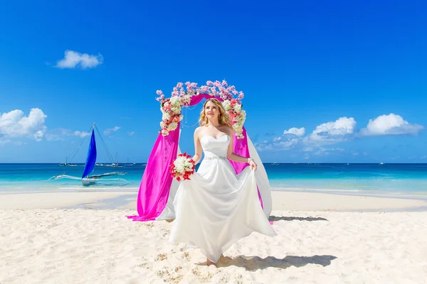 Ceremonia ślubna na tropikalnej plaży w kolorze fioletowym. Szczęśliwy blond Brid — Zdjęcie stockowe