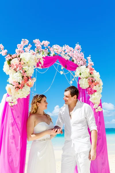 Bruid geven een verlovingsring aan zijn bruidegom onder de boog deco — Stockfoto
