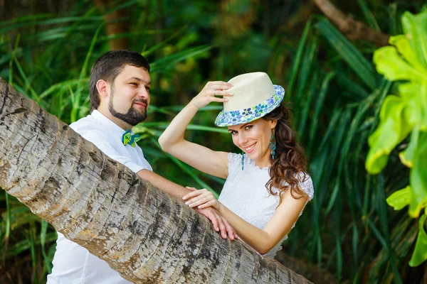 Happy groom and bride having fun in a tropical jungle under the — Stock Photo, Image