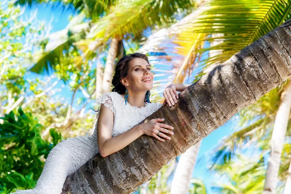 Giovane bella sposa in abito da sposa bianco sulla palma su — Foto Stock