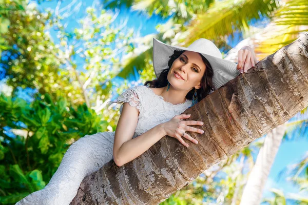 Giovane bella sposa in abito da sposa bianco sulla palma su — Foto Stock