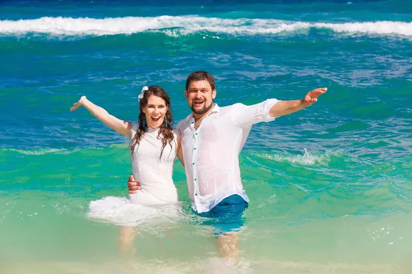 Mariée heureuse et marié s'amuser dans les vagues sur un beac tropical — Photo