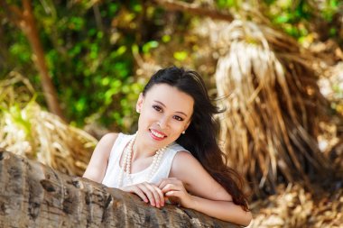 Young beautiful Asian bride under the palm tree on a tropical is