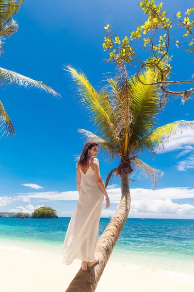 Young beautiful bride in white wedding dress on the palm tree on — Stock Photo, Image