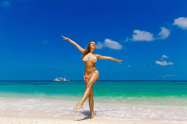 Happy beautiful young girl in bikini on a tropical beach. Blue s — Stock Photo, Image