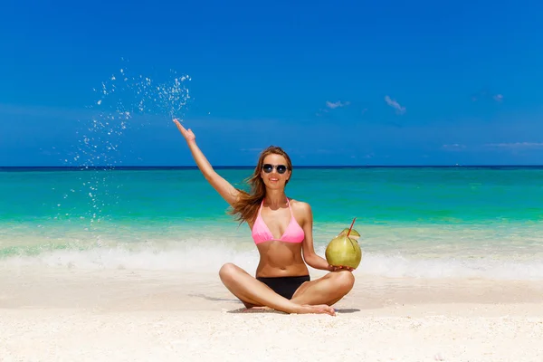 Gelukkig mooi jong meisje in bikini met kokosnoot op een tropische — Stockfoto