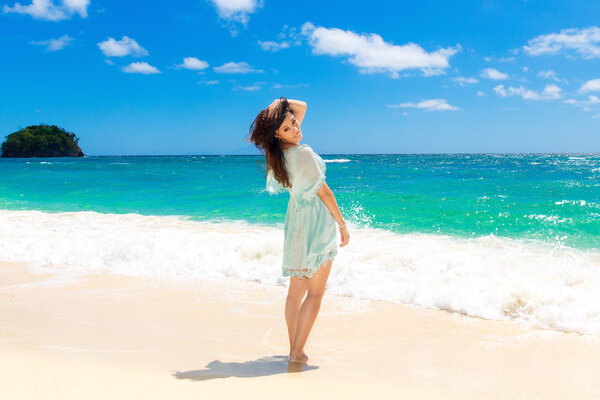 Young beautiful Asian  girl in blue dress on the beach of a trop