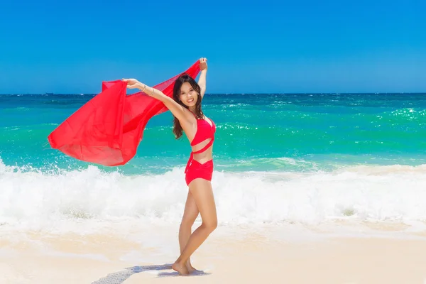 젊은 아름 다운 아시아 여자는 너무의 해변에 붉은 천으로 — 스톡 사진