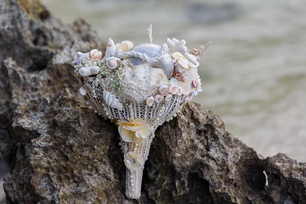 Bouquet da sposa nuziale sulle rocce. Mare blu sullo sfondo. Matrimonio e luna di miele ai tropici . — Foto Stock