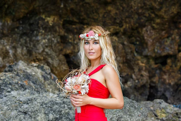 Giovane bella ragazza in tropici con una ghirlanda, tenendo una bouque — Foto Stock