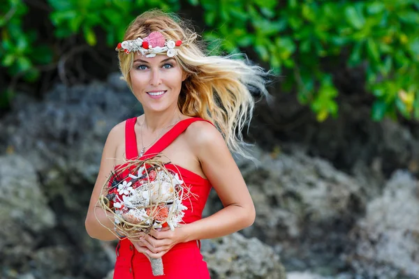 Young beautiful girl  in tropics with a wreath, holding a bouque — Stock Photo, Image