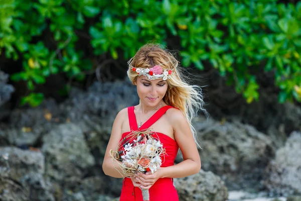 Giovane bella ragazza in tropici con una ghirlanda, tenendo una bouque — Foto Stock