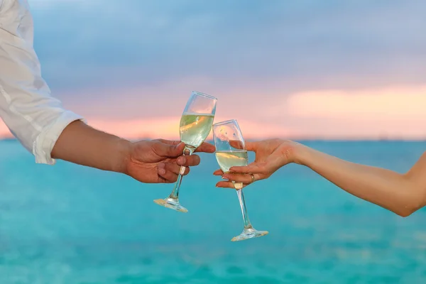 Man and woman clanging wine glasses with champagne at sunset — Stock Photo, Image
