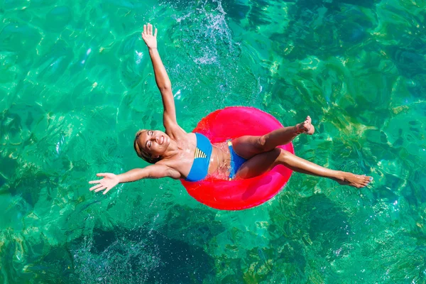 Молодая красивая девушка в бикини плавает в тропическом море на траве — стоковое фото