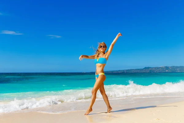 Ung vacker flicka i blå bikini att ha kul på en tropisk bea — Stockfoto