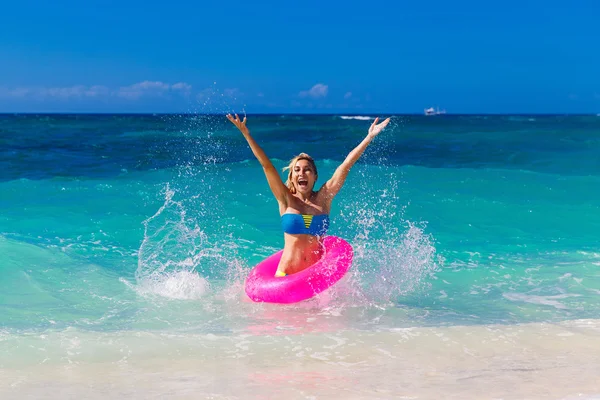 Mooie meisje in bikini zwemt in een tropische zee op een rubb — Stockfoto