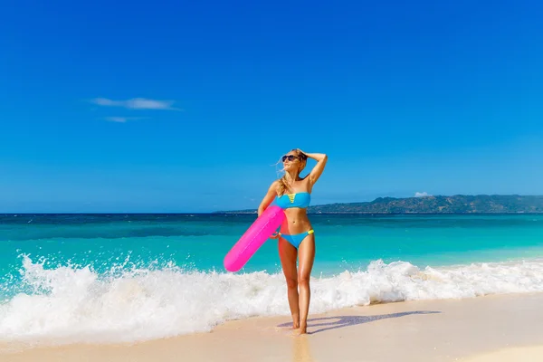 Mooie meisje in blauwe bikini plezier op een tropische bea — Stockfoto