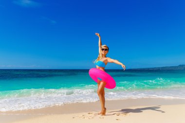 Genç güzel kız mavi bikini bir tropikal bea üzerinde eğleniyor