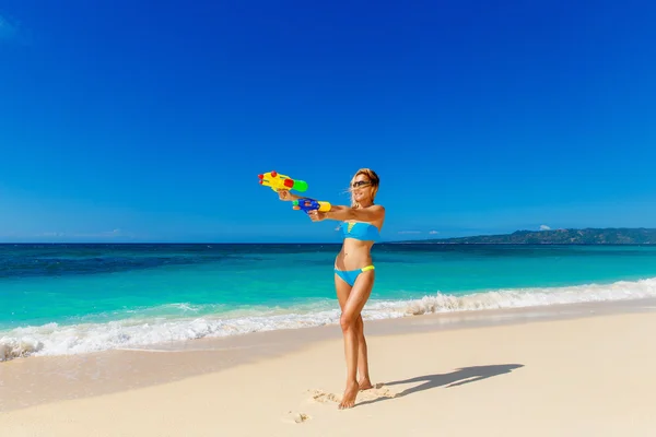 Mooie meisje in blauwe bikini plezier op een tropische bea — Stockfoto