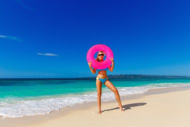 Genç güzel kız mavi bikini bir tropikal bea üzerinde eğleniyor